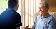 male customer sat on chair talking to carer