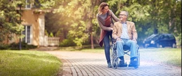 lady walking with an elderly in a wheelchair