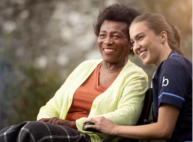 Bluebird Care live-in carer with an elderly patient smiling