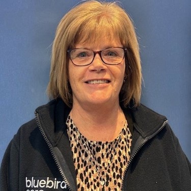 Headshot of Sue Stephens on blue background
