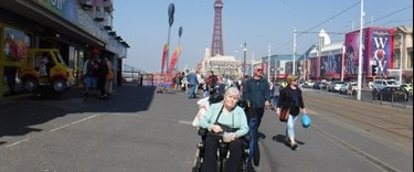 Lyn on promenade blackpool in her green jumper in her wheelchair