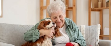 elderly lady hugging her pet dog