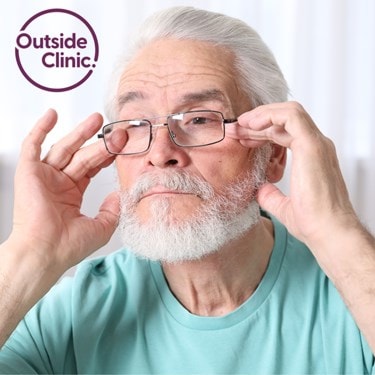 Elderly man adjusting his glasses