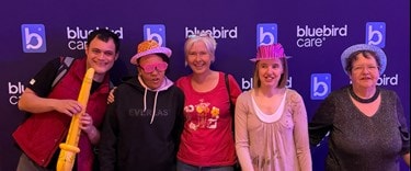 Five guests have a photo at Bluebird Care's SEND Nightclub for adults with learning disabilities.