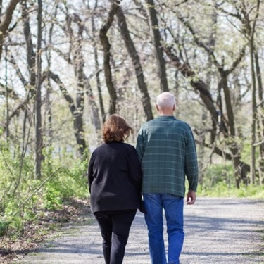 older couple walking in the woods in spring
