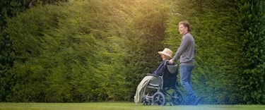 A carer walking a customer in a wheelchair