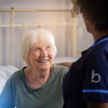 elderly lady getting assistance up by a carer