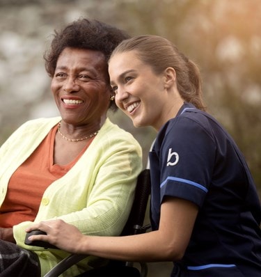 care expert and female customer in wheelchair looking into the distance