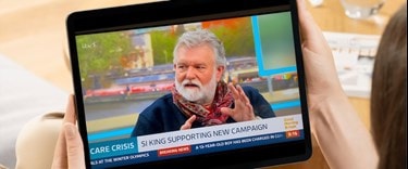 a Lady watching care news on an ipad