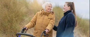 Elderly lady chatting on an assisted walk with a carer