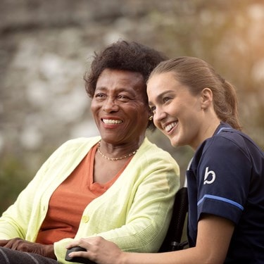care expert and female customer in wheelchair looking into the distance