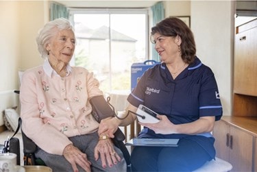 image of customer getting their blood pressure checked by a care professional