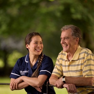 Care Expert and male customer leaning on fence