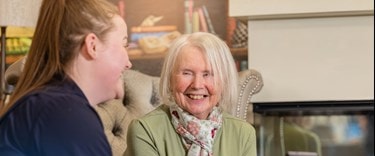 carer chatting to an elderly lady at her home