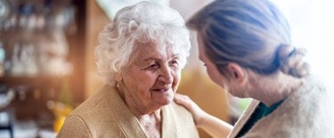 Chatting about care at home with an elderly lady and a family member
