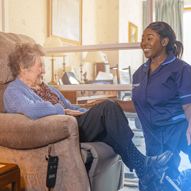 Carer taking care of customer in chair