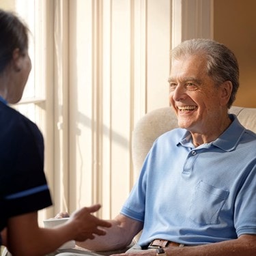 male customer sat on chair talking to carer