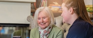 A carer and an elderly lady chatting