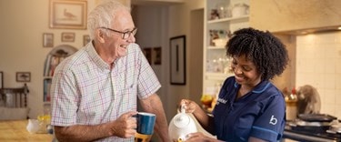 Care at night. Evening cup of tea with a carer and an elderly