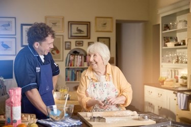 A Bluebird Care Care Expert baking with an older lady in her kitchen