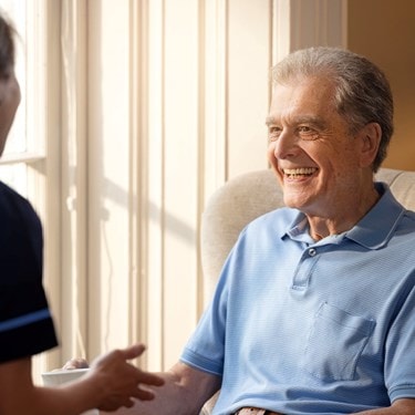 male customer sat on chair talking to carer