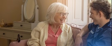 A customer and care assistant talking and smiling