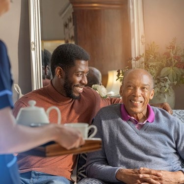 male customer and relative sat on sofa