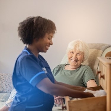 Care expert tidying drawers and customer smiling