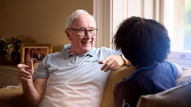 male customer and female carer on sofa