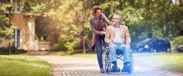 lady walking with an elderly in a wheelchair