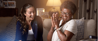 Carer and an elderly lady enjoying time and each others company on a couch