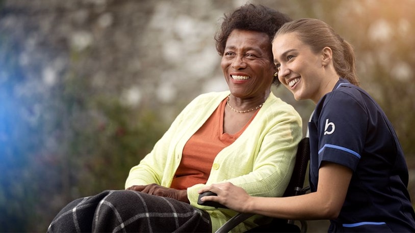 care expert and female customer in wheelchair looking into the distance