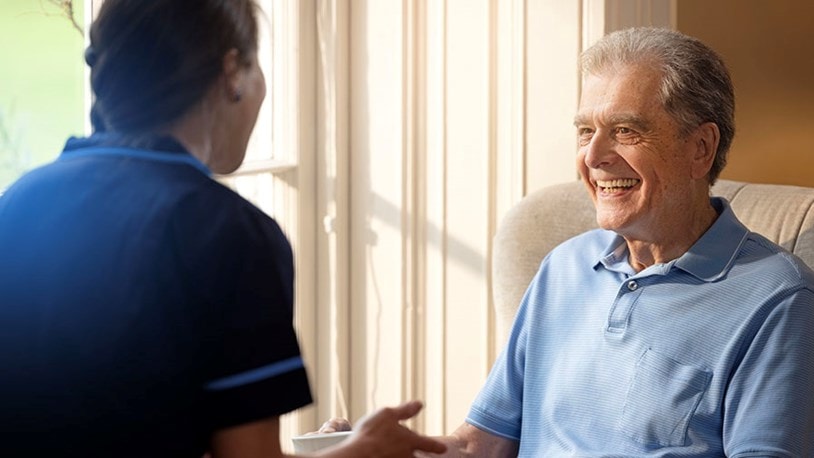 male customer sat on chair talking to carer