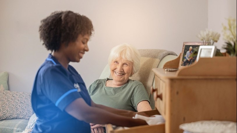 A carer packing away laundry for an elderly at home