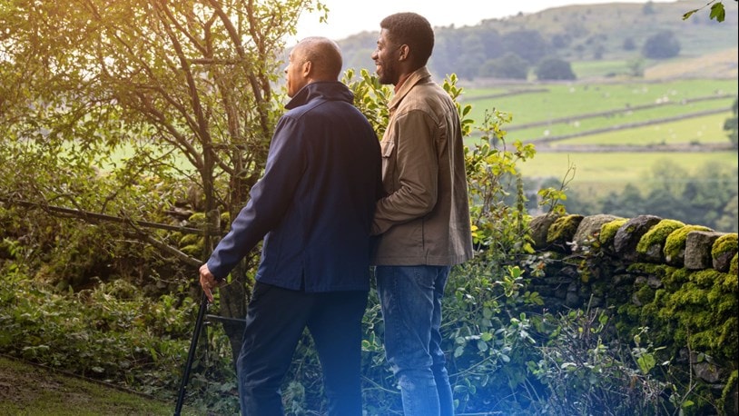 An elderly walking outside with his son