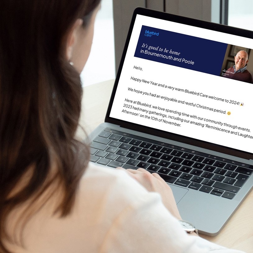 Person reading a New Year message from Bluebird Care on a laptop screen