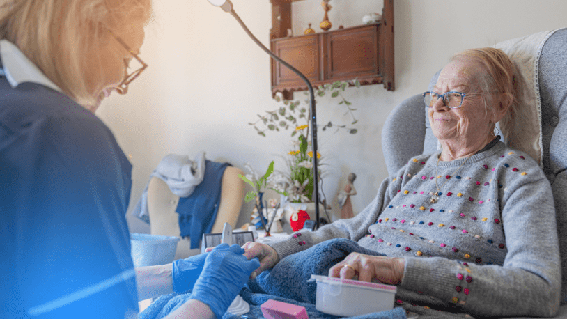 Elderly woman receiving nail care from care professional