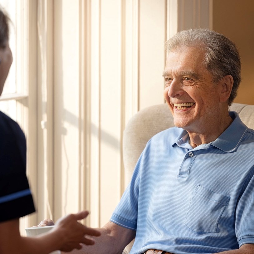 male customer sat on chair talking to carer