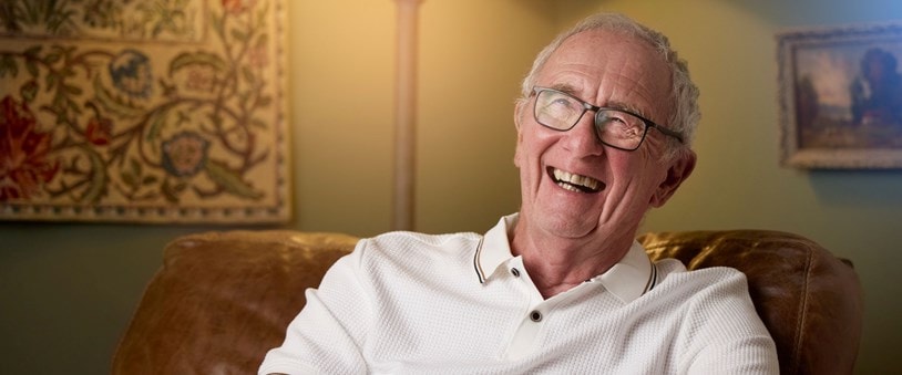 Happy Elderly Male Customer Sitting in a Chair