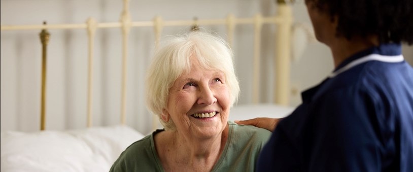 Elderly Customer Looking Up at Care Expert