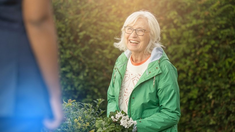 picking flowers in the garden with a carer and an elderly lady