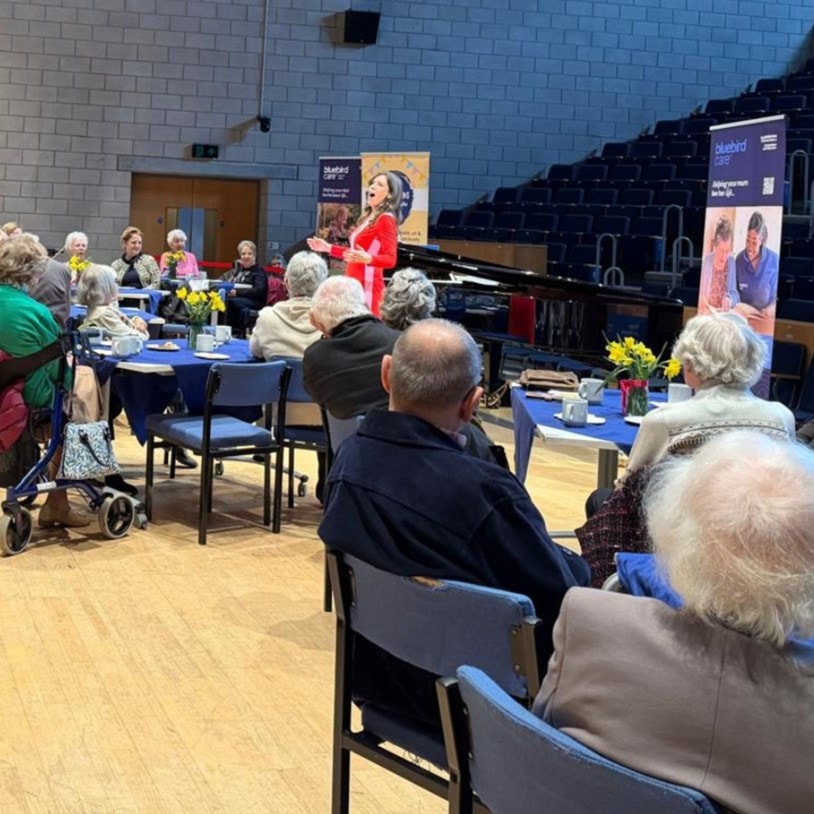 Lady signing opera on stage AgeUk